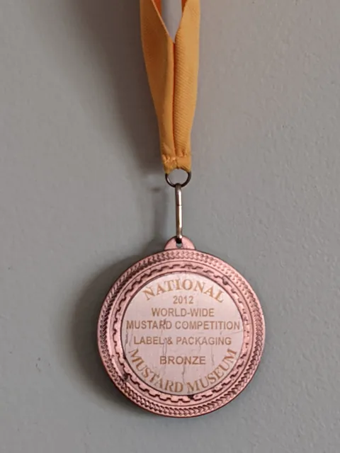 The 2012 National Mustard Museum World-Wide Mustard Competition bronze medal for Label & Packaging, on an orange ribbon